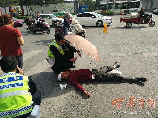 暖心！交警为车祸伤者打伞遮阳（图片） - 1