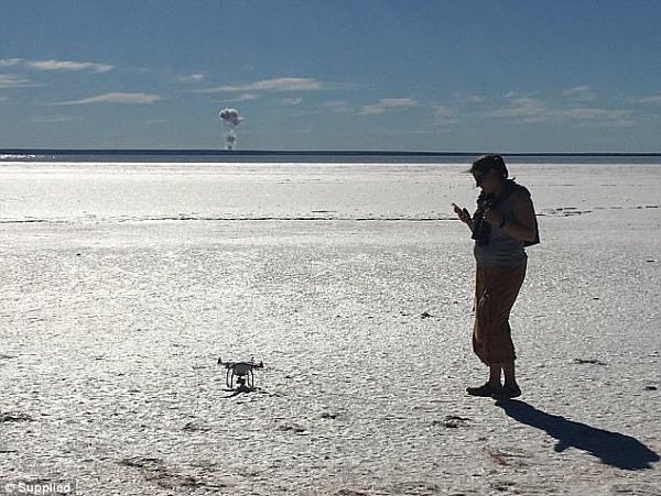 Jason Wright took a photo of a 'mushroom cloud' which formed over the Woomera Prohibited Area on Saturday while he was on the edge of Lake Hart. Pictured in the photo is his partner Ariane Montminy-Roberge