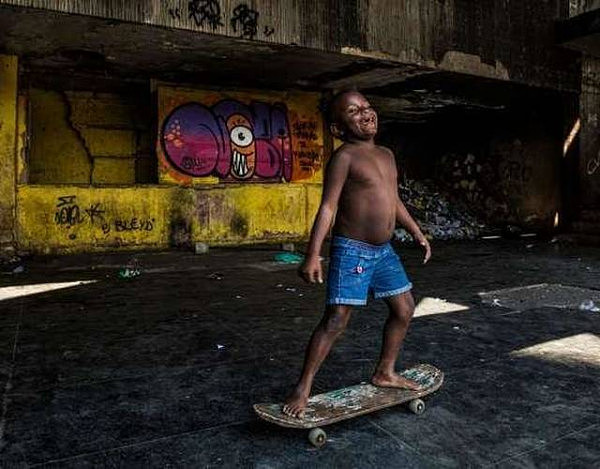 图为一名小孩在Mangueira的巴西地理与统计研究所（IBGE）的废弃建筑物里玩滑板。