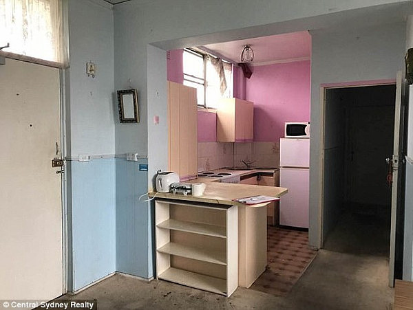 The kitchen fails to hide the apartment's age, with dated tiles, bright pink paint  and brown stains on the nearby carpet