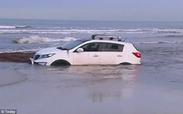 The woman had to be pulled from harm's way when her car became submerged on the beach