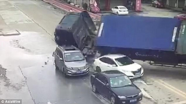 惊魂一刻！中国东莞超载大货车突然失控侧翻 两辆小车瞬间被夷平（视频） - 2