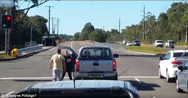 Dash cam footage has captured the shocking moment a man punches a woman in the face while stopped at a traffic light