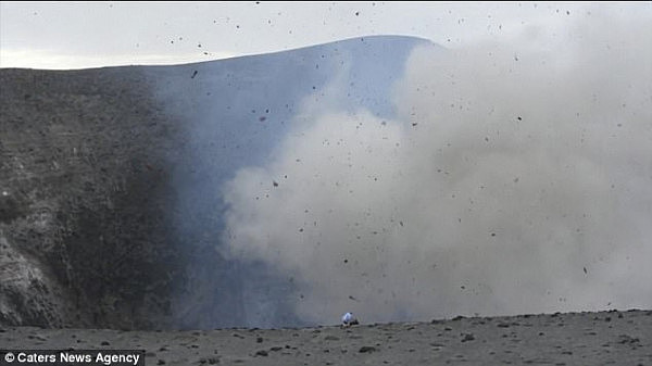 Perched at the crater of the Yasur Volcano, the 51-year-old moves back as thick smoke engulfs the area