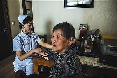 8月31日，燕郊一养老院内，护士来到张国英老人的房间为她测血压。图片来源：新京报