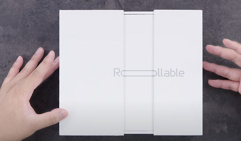 LG Rollable smartphone retail packaging on gray table.