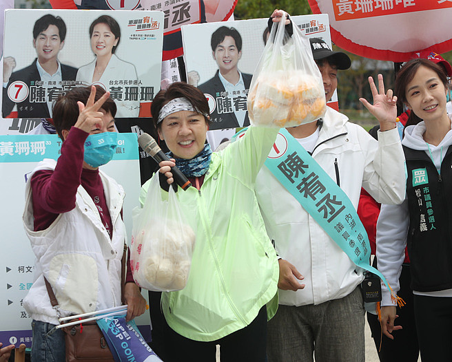 無黨籍台北市長候選人黃珊珊（中）6日舉辦「偉大市民向前騎活動」，來到內湖科技園區向當地民眾拜票，接過民眾贈送的包子高喊包中。（鄭任南攝）