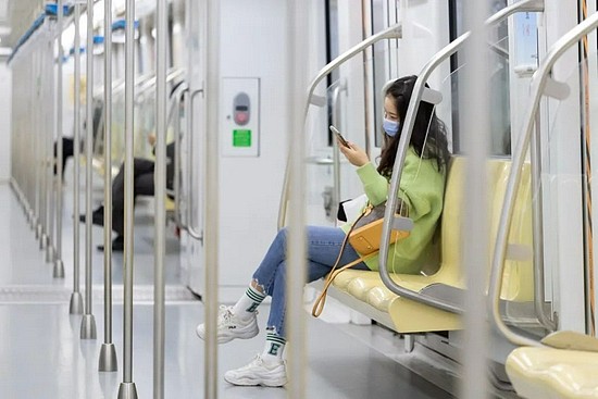 一位乘客在地铁上浏览手机 张梦 摄