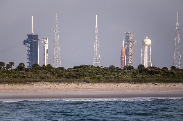 发射前，39A发射台矗立着猎鹰火箭与龙飞船；39B发射台则是NASA用于登月的火箭太空发射系统SLS，后者将于今天夏天进行首次无人绕月飞行。