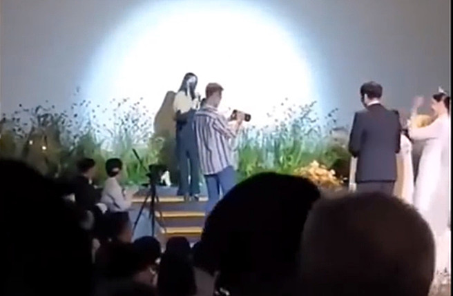 網友挖出IU參加李鍾碩弟弟唱祝歌影片，新娘興奮打新郎背。（圖／翻攝自微博）