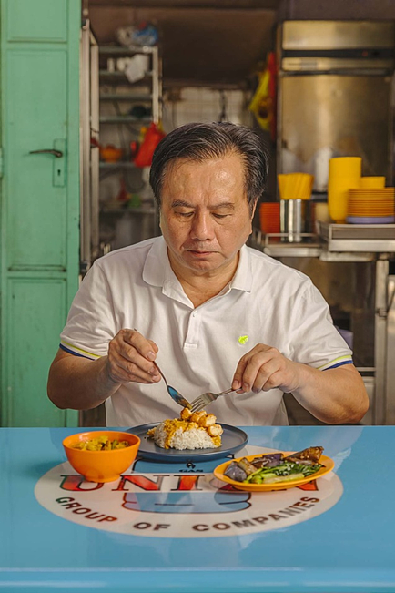 新加坡摊贩卢老板正在试吃以Eat Just的人造鸡肉为原料制作的咖喱鸡块饭