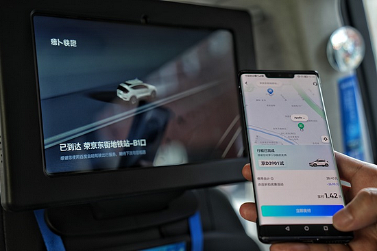 一名在北京亦庄乘坐自动驾驶出租车的乘客准备付车费。新华社记者 彭子洋摄