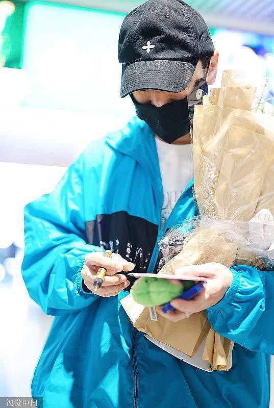 黄晓明穿亮蓝色运动衫戴棒球帽 为粉丝签名获赠送花 - 2
