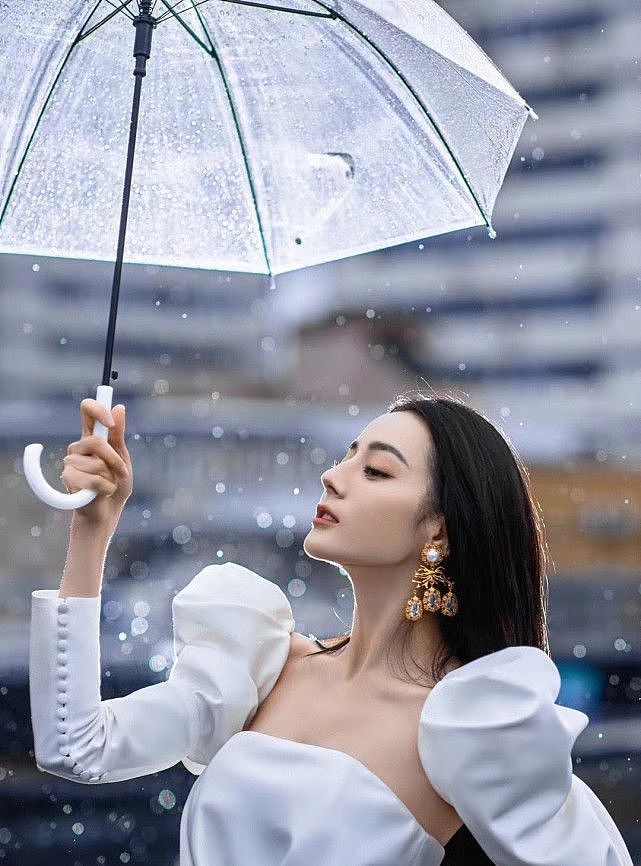 热巴久违的名场面曝光！穿白色礼服站在雨天里，打塑料伞有奢华感 - 6