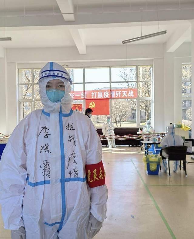运动员李晓霞主动当抗疫志愿者，穿着厚重防护服，站着脸上汗可见 - 4