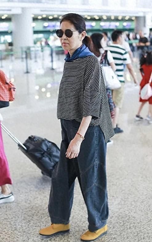 倪萍瘦身后真时髦，穿条纹T恤+阔腿裤走机场，戴猫咪墨镜不像65岁 - 1