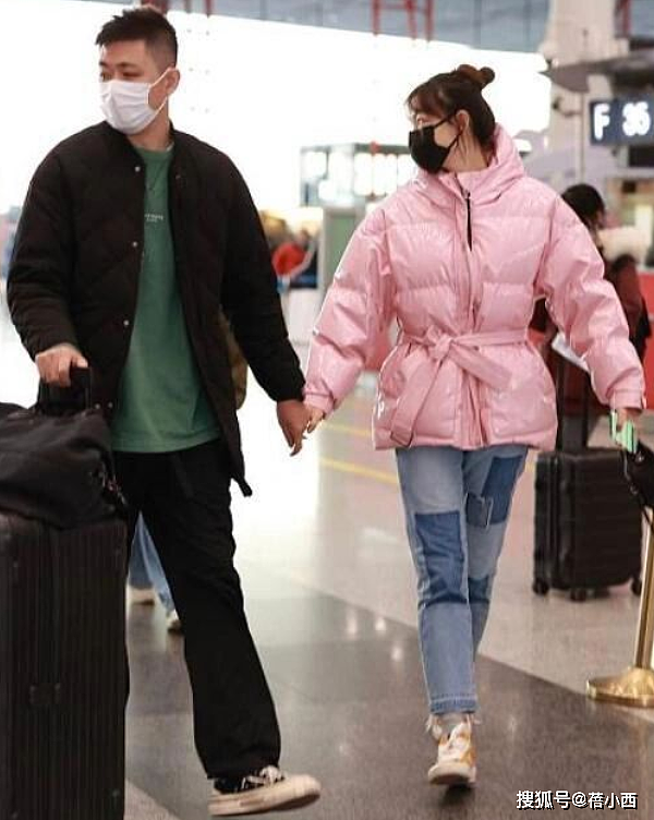 “李艾牵手老公”走机场，穿粉色羽绒服配牛仔裤，被宠的人真幸福 - 2