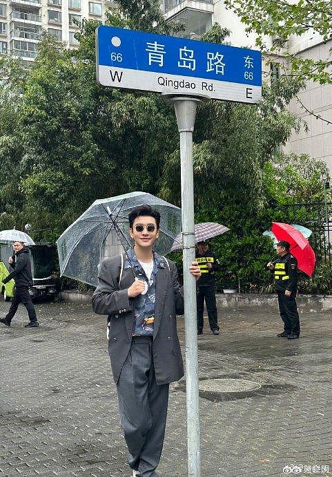 怎么感觉拍打卡照的晓明哥有点可爱呢～撑着雨伞在青岛路下咔嚓拍照… - 1