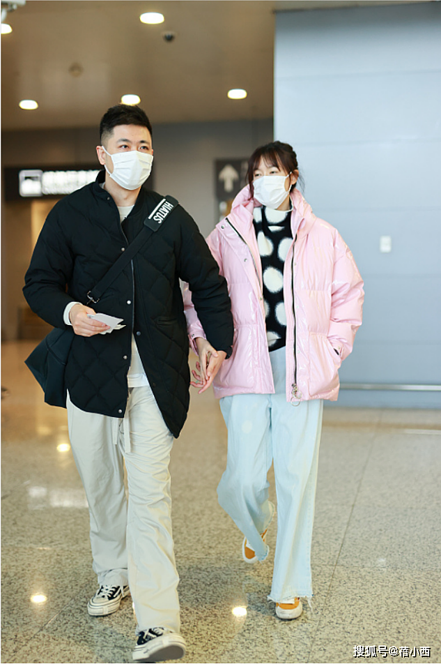 “李艾牵手老公”走机场，穿粉色羽绒服配牛仔裤，被宠的人真幸福 - 5