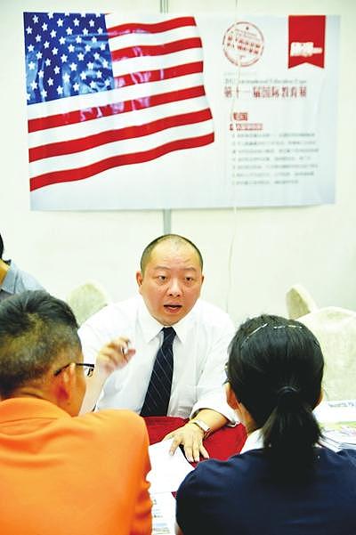 2012年6月24日，在杭州举办的第十一届国际教育展上，一名国外高校的招生老师（中）在做留学咨询。图片来源 CFP